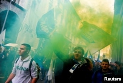 Italian Lega supporters hold flares as they arrive at political rally led by leader Matteo Salvini, in Milan, Italy, Feb. 24, 2018.