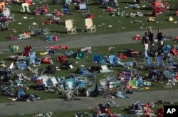 FILE - Investigators work at a festival grounds across the street from the Mandalay Bay Resort and Casino in Las Vegas, Oct. 3, 2017.