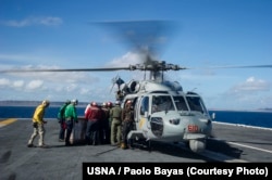 Sailors aboard the U.S. Navy's forward-deployed aircraft carrier USS George Washington (CVN 73) load containers of water onto an MH-60S Seahawk from the "Golden Falcons" of Helicopter Sea Combat Squadron (HSC) 12 in support of Operation Damayan, Nov. 15,