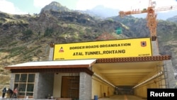 FILE - Laborers work next to the newly constructed Atal Tunnel on the Leh-Manali highway in Sissu village in Lahaul and Spiti district in the northern state of Himachal Pradesh, India, Sept. 22, 2020. 