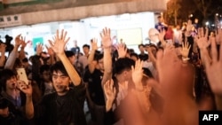 FILE - Pro-democracy supporters celebrate after pro-Beijing candidate Junius Ho lost a seat in the district council elections in Tuen Mun district of Hong Kong, early on Nov. 25, 2019.