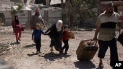 A girl ducks as she flees with her brothers in the al-Rifai neighborhood as Iraqi special forces battle Islamic State militants in western Mosul, Iraq, May 17, 2017.