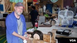 Michael Rohde demonstrates a pendulum-powered light that he's perfecting at OlyMEGA, the Olympia, Washington maker space. (Tom Banse for VOA)