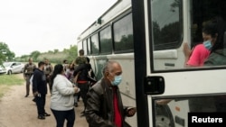Asylum-seeking migrants from Venezuela board a U.S. Border Patrol's bus to be transported after crossing the Rio Grande River into the United States from Mexico in Del Rio, Texas, May 27, 2021. 