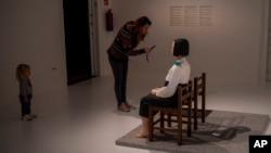 A visitor takes photos of the statue "A Girl of Peace," by Kim Eun-Sung and Kim Seo-Kyung, at Barcelona, Spain's Museum of Forbidden Art on Nov. 8, 2023. Exhibited as part of the Aichi Triennale 2019 in Japan, the artwork received threats for being "anti-Japanese propaganda."