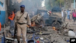 A Somali soldier walks near wreckage of vehicles after a car bomb was detonated in Mogadishu, Oct 28, 2017. 