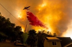 An air tanker drops retardant as the LNU Lightning Complex fires tear through the Spanish Flat community in unincorporated Napa County, Calif., Aug. 18, 2020.