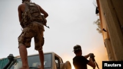 Pejuang yang mendukung pemerintah yang berkuasa di Libya terlibat dalam baku tembak dengan pasukan pendukung Khalifa Haftar, seorang Marsekal Lapangan Libya yang menolak tunduk pada pemerintah, di luar wilayah Tripoli, Libya, pada 25 Mei 2019. (Foto: Reuters/Goran Tomasevic)