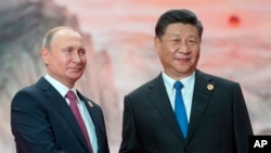 FILE - Chinese President Xi Jinping and Russian President Vladimir Putin are pictured at the Shanghai Cooperation Organization Summit in Qingdao in eastern China's Shandong province, June 10, 2018.