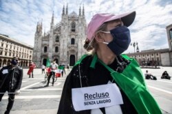 People stage a protest against government and for work rights in front of the Duomo gothic cathedral, in Milan, Italy, May 4, 2020.
