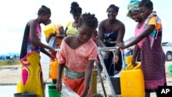 A young girl fetches water at a camp for displaced survivors of cyclone Idai in Beira, Mozambique, April, 2, 2019.