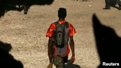 Yon manm gang kap manche nan Pòtoprens apre l fin antre nan lese frape ak militè Nasyon Zini yo. Foto Achiv: 22 desanm 2006. Nan yon operasyon kote omwen 9 moun pou pipiti te pèdi lavi yo. REUTERS/Eduardo Munoz)