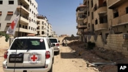 FILE - A June 1, 2016 photo released by the International Committee for the Red Cross shows the first humanitarian aid convoy in Daraya, Syria. 