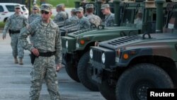 National Guard troops arrive at a mall complex that serves as staging area for the police in Ferguson, Missouri, Aug. 18, 2014. 