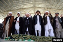 Afghans offer funeral prayers behind the body of a civilian killed in Sunday's deadly suicide attack at a voter registration center, in Kabul, Afghanistan, April 23, 2018.