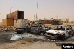 FILE - Vehicle wreckages are seen after a suicide car bomber blew himself at a checkpoint near Misrata, Libya, May 21, 2015.