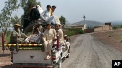 A family flees from neighboring Orakzai tribal region because of fighting between security forces and militants, March 27, 2010. A suicide bomber attacked a crowded festival and market in the region Friday.