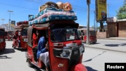 Residents ride in rickshaws as they flee following renewed clashes between rival factions in the security forces, who have split in a dispute over an extension to the president's term in Hodan district of Mogadishu, Somalia, April 27, 2021.