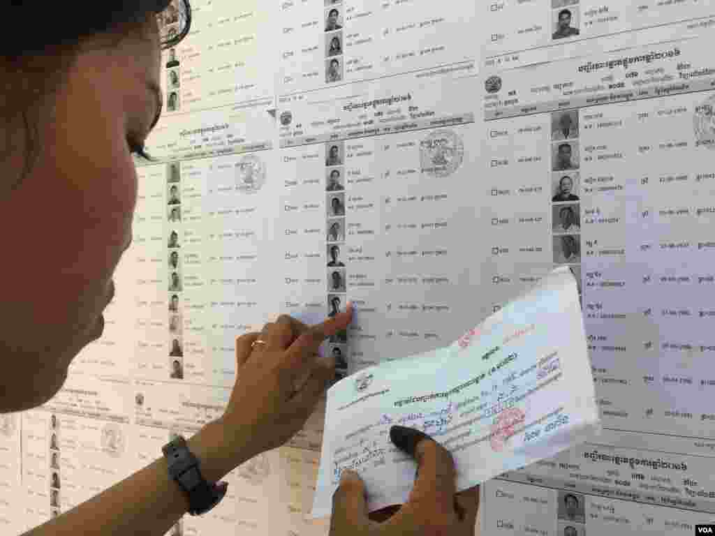 កញ្ញា​​​ជិន​​​ ស្រី​​​ធុច​​​ អាយុ​​​១៨​​​ឆ្នាំ ​​​សកម្មជន​​​របស់​​​គណបក្ស​​​សង្គ្រោះជាតិ​​​ កំពុង​​​រក​​​ឈ្មោះ ​​​និង​​​លេខរៀង​​​របស់​​​អ្នក​​​បោះឆ្នោត​​​នៅ​​​ក្នុង​​​ឃុំ​​​ដំដែក​​​ស្រុក​​​សូត្រ​​​និគម​​​នៅ​​​ការិយាល័យ​​​បោះឆ្នោត​​ក្នុង​​​វិទ្យាល័យ​​​ដំដែក។ (ផន បុប្ផា/VOA)