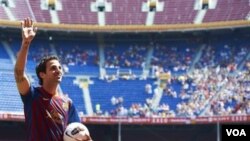 Pemain baru Barcelona Cesc Fabregas melambaikan tangan ketika diperkenalkan di stadion Camp Nou Barcelona, Senin (15/8).