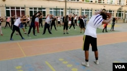 Teenagers stretch during boxing training at the Brussels Boxing Academy, Brussels, Belgium, Sept. 2016. (M. van der Wolf/VOA)
