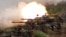 FILE- In this May 25, 2017, file photo, a line of U.S. M60A3 Patton tank fire at targets during the annual Han Kuang exercises on the outlying Penghu Island, Taiwan.
