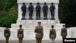 FILE - Senior officers and soldiers of the Household Division stand in front of Guards Memorial in St James's Park during a two minute silence to commemorate the 75th Anniversary of VE Day, London, May 8, 2020.