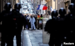 Police officers are seen in front of protesters wearing yellow vests during a demonstration in Marseille, France, Jan. 19, 2019.