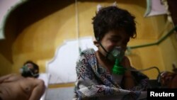 A child and a man are seen in hospital in besieged eastern Ghouta, near Damascus, Syria, Feb. 25, 2018.