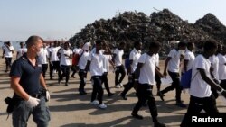 Migrants are escorted by Italian police after disembarking from Vos Hestia ship of NGO "Save the Children" in the Sicilian harbour of Augusta, Italy, Aug. 4, 2017.