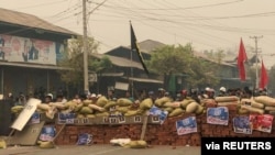 FILE - Protesters defend themselves from the troops in Kale, Sagaing region, Myanmar, March 28, 2021.