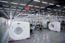 An employee wearing a face mask is seen at a workshop of computed tomography (CT) scanners of medical device firm Siemens Healthineers in Shanghai, China, as the country is hit by an outbreak of a new coronavirus, Feb. 24, 2020.