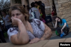 FILE - Melanie Starnauld and her 19-year-old son Mathew, who lost their home to Hurricane Harvey, await to be evacuated from Rockport, Texas, Aug. 26, 2017.