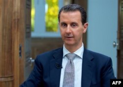 FILE - A handout picture released by the Syrian presidency's press office shows Syrian President Bashar al-Assad during an interview with AFP in Damascus, April 12, 2017.