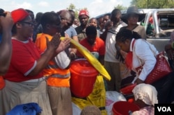Due to erratic donor aid, local well-wishers are coming in to help flood victims with whatever they can provide. (L. Mesina for VOA)