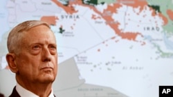 FILE - Secretary of Defense Jim Mattis stands in front of a map of Syria and Iraq, while speaking to the media about the Islamic State group at the Pentagon, May 19, 2017.