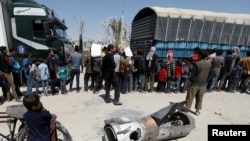 A boy stands next to the remains of a missile, in Douma, near Damascus, Syria, April 16, 2018.