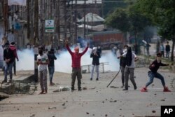 Kashmiri protesters throw rocks and bricks at Indian paramilitary soldiers near the site of a gunbattle in Srinagar, Indian-controlled Kashmir, May 5, 2018.