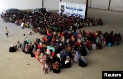Migrants are seen in a shelter after they were relocated from government-run detention centers, after getting trapped by clashes between rival groups in Tripoli, Libya, Aug. 30, 2018.
