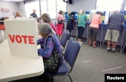 Voters fill in their ballots at a crowded polling station on North Carolina's first day of early voting for the general elections, in Carrboro, North Carolina, Oct. 20, 2016.
