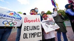 FILE - Children hold signs during a demonstration by a coalition representing Tibetans, Uyghurs, Southern Mongolians, Hong Kongers, Taiwanese and Chinese rights activists in Boston, June 23, 2021.