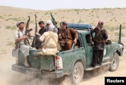 Afghan local police (ALP) sit at the back of a truck near a frontline during a battle with the Taliban, at Qalay-i-zal district, in Kunduz province, Afghanistan, Aug. 1, 2015. Lacking oversight, ALP forces have in the past been accused of various abuses.
