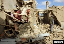 FILE - An Afghan man inspects a house destroyed during an airstrike called in to protect Afghan and U.S. forces during a raid on suspected Taliban militants, in Kunduz, Afghanistan, Nov. 4, 2016.