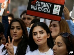 Demonstrators gesture and hold banners during a Solidarity with Refugees march from Marble Arch to Parliament in London, Sept. 12, 2015.