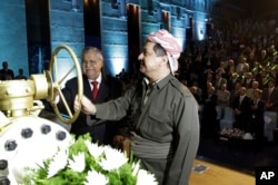 FILE - Kurdish president Massud Barzani (R), and Iraqi President Jalal Talabani open a ceremonial valve during an event to celebrate the start of oil exports from the autonomous region of Kurdistan, in the northern Kurdish city of Irbil, June 1, 2009.