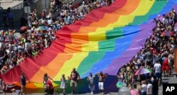 People carry a flag during the Utah Pride parade in Salt Lake City, June 3, 2018.
