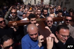 Local Arab Christian pilgrims carry a wooden cross along the Via Dolorosa (Way of Suffering) in Jerusalem’s Old City during the Good Friday procession on March 25, 2016.