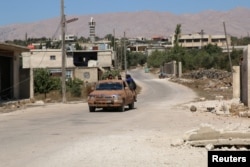 Rebel fighters ride a vehicle in Jubata al-Khashab, in Quneitra countryside, Syria Sept. 11, 2016.