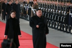 North Korean leader Kim Jong Un and wife Ri Sol Ju inspect an honour guard before leaving Pyongyang for a visit to China, this Jan. 7, 2019 photo released by North Korea's Korean Central News Agency (KCNA) in Pyongyang, Jan. 8, 2019.