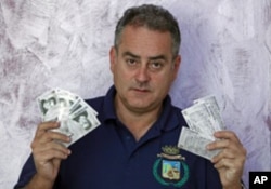 Mayor Luca Sellari displays Filettino's own bank currency - the 'Fiorito' - at his office in Filettino, Italy, August 2011.